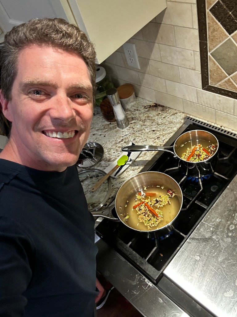 Chris, founder of Daybreak Brews, brewing chai spices on the stove
