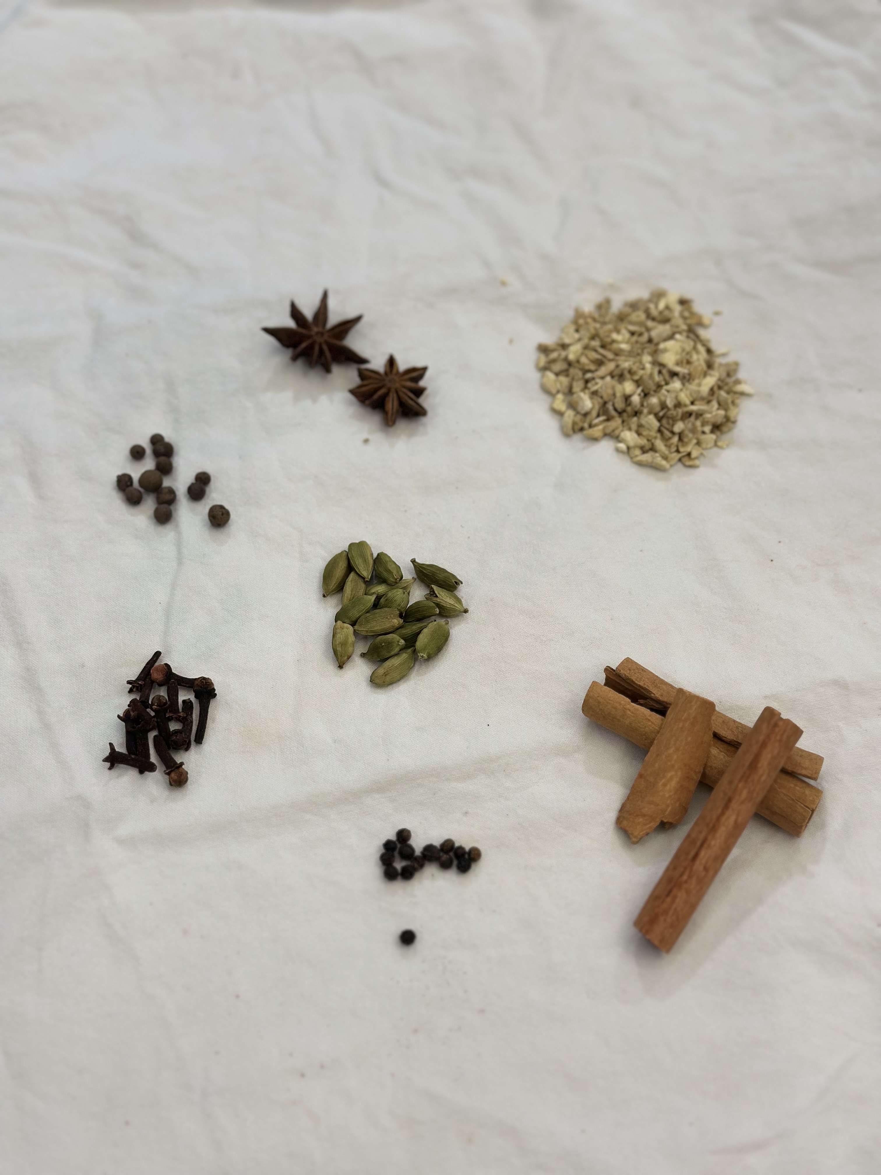 Cinnamon bark, cardamom pods, cloves and fresh ginger before brewing